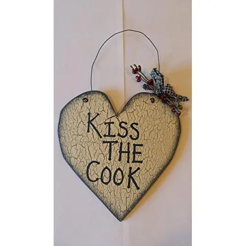 Rustic Heart Shaped Wooden Sign &quotKiss the Cook&quot written in blue with Off White Crackle painted Background and blue border. Wire hanger with blue gingham and red berries tied in a bow. Measures 12 x 7-1/2 x 3/16